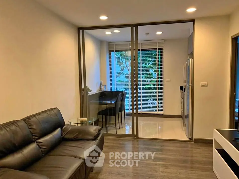 Modern living room with glass partition and cozy seating area, perfect for urban living.