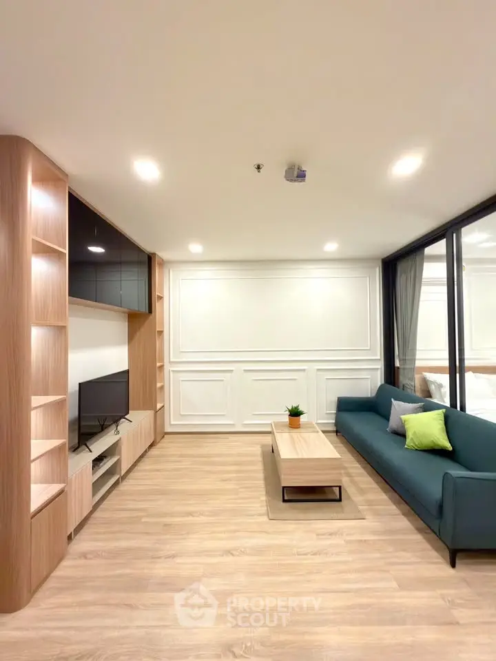 Modern living room with sleek wooden flooring, stylish shelving, and cozy seating area.
