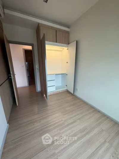 Spacious bedroom with built-in closet and wooden flooring