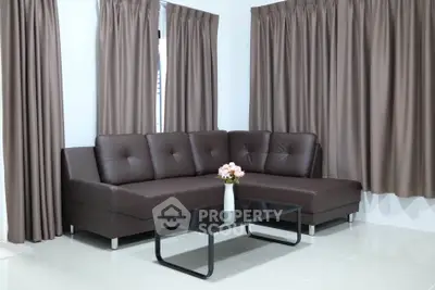 Modern living room with sleek brown sectional sofa and elegant curtains.