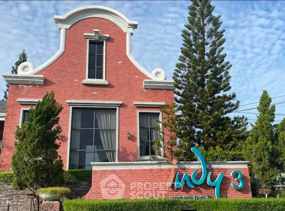 Charming red brick building with lush greenery and unique architectural design.