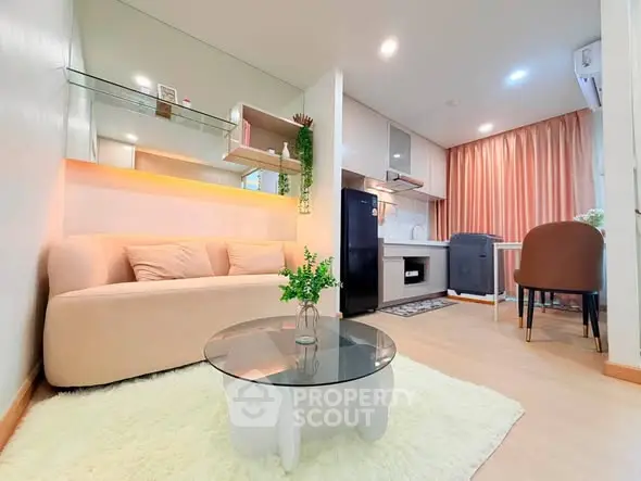 Modern open-layout living room with cozy sofa and stylish kitchen in compact apartment.