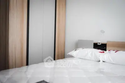 Modern bedroom with sleek wardrobe and stylish bedding in a contemporary apartment.