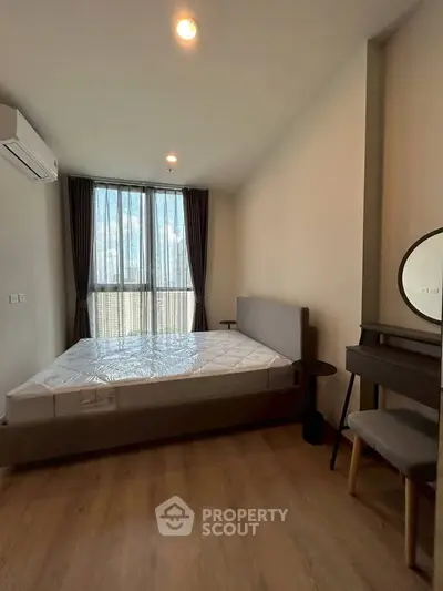 Modern bedroom with large window and stylish furniture in a cozy apartment.