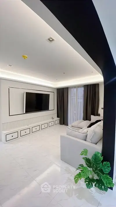 Modern living room with sleek design, large TV, and elegant lighting