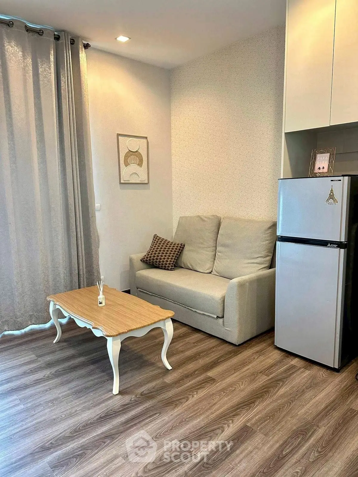 Cozy living room with elegant sofa and modern fridge, perfect for urban living.