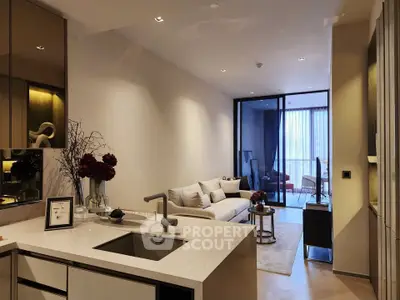 Modern open-plan living room with elegant kitchen and cozy seating area, featuring stylish decor and natural light.