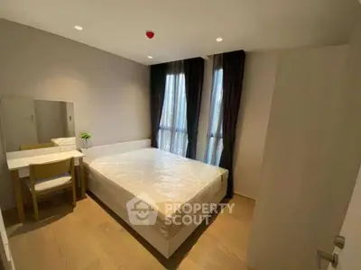 Modern bedroom with natural light, featuring a cozy bed and stylish furniture.