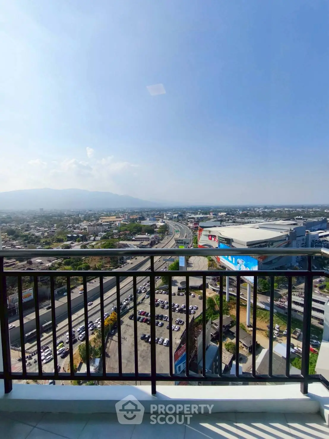 Stunning balcony view overlooking cityscape and mountains, perfect for urban living.