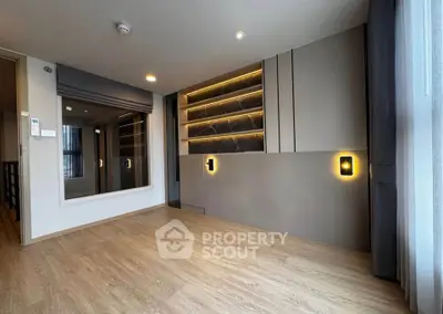 Modern living room with sleek built-in shelving and large window for natural light.