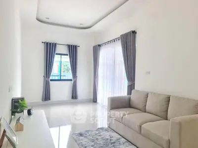 Bright and spacious living room with modern decor and large windows.