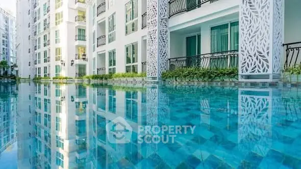 Luxurious apartment complex with stunning poolside view and elegant architectural design.