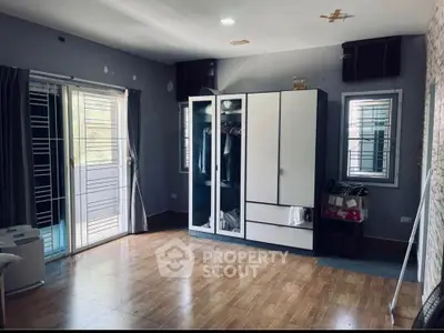 Spacious bedroom with modern wardrobe and balcony access