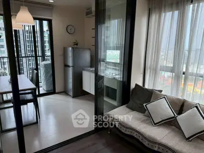 Modern condo with open kitchen and cozy living area, featuring large windows and city view.