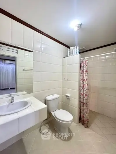 Spacious bathroom with modern fixtures and floral shower curtain