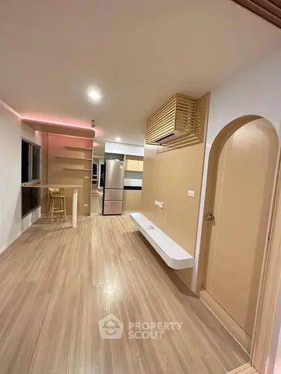 Modern open-plan living room with sleek kitchen and stylish wooden flooring.