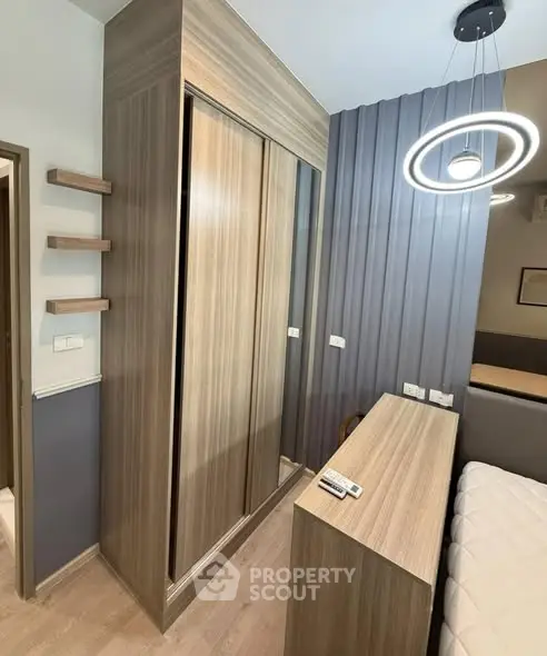 Modern bedroom with stylish wooden wardrobe and contemporary lighting