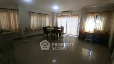 Spacious living room with dining area and large windows for natural light.