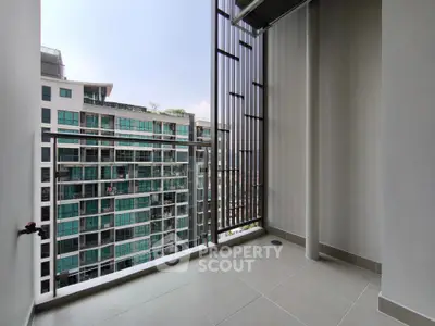 Spacious balcony with modern railing and city view in high-rise apartment