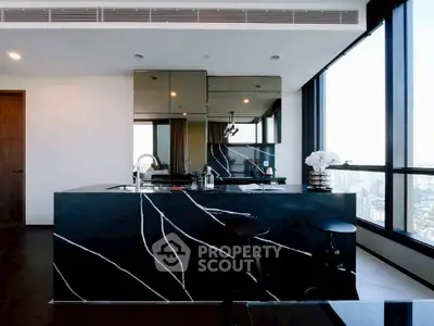 Luxurious modern kitchen with sleek black marble island and panoramic city views.
