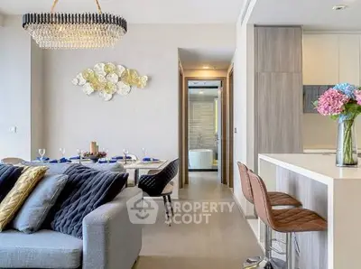 Luxurious open-plan living room with elegant dining area and modern kitchen, featuring stylish decor and a cozy ambiance.