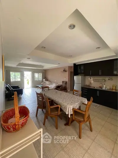 Spacious open-plan living and dining area with modern kitchen and ample natural light.