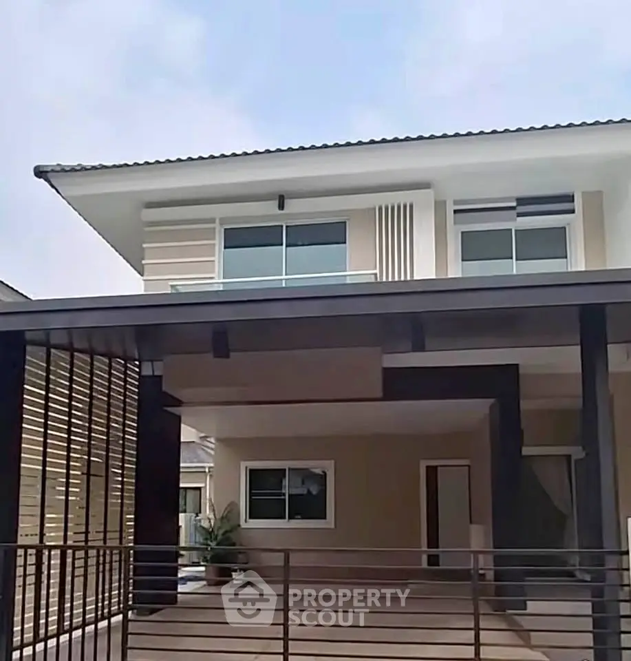Modern two-story house with spacious carport and sleek architectural design.