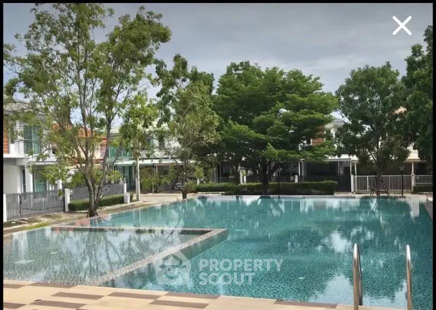 Luxurious residential pool surrounded by lush greenery and modern architecture.