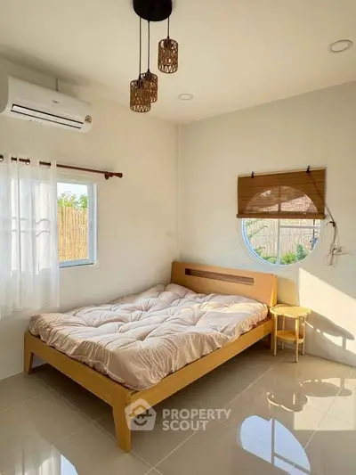 Cozy bedroom with natural light, featuring a modern bed and stylish decor, perfect for relaxation.
