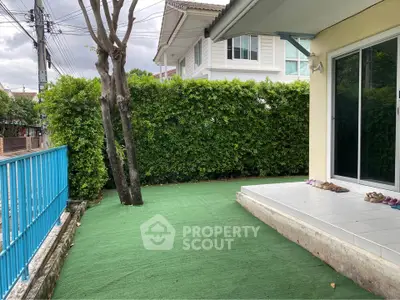 Charming house exterior with lush greenery and spacious patio area.