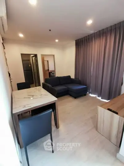 Modern living room with cozy sofa and dining area in open layout apartment.