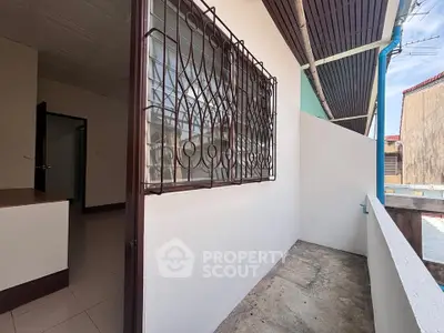 Spacious balcony with protective window grill in urban residential area