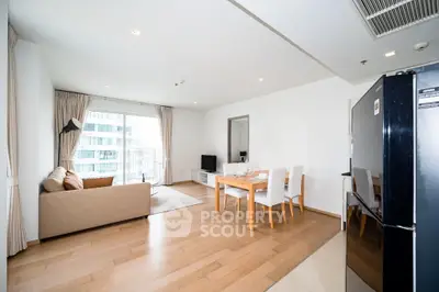 Spacious modern living room with dining area and large windows in a stylish apartment.