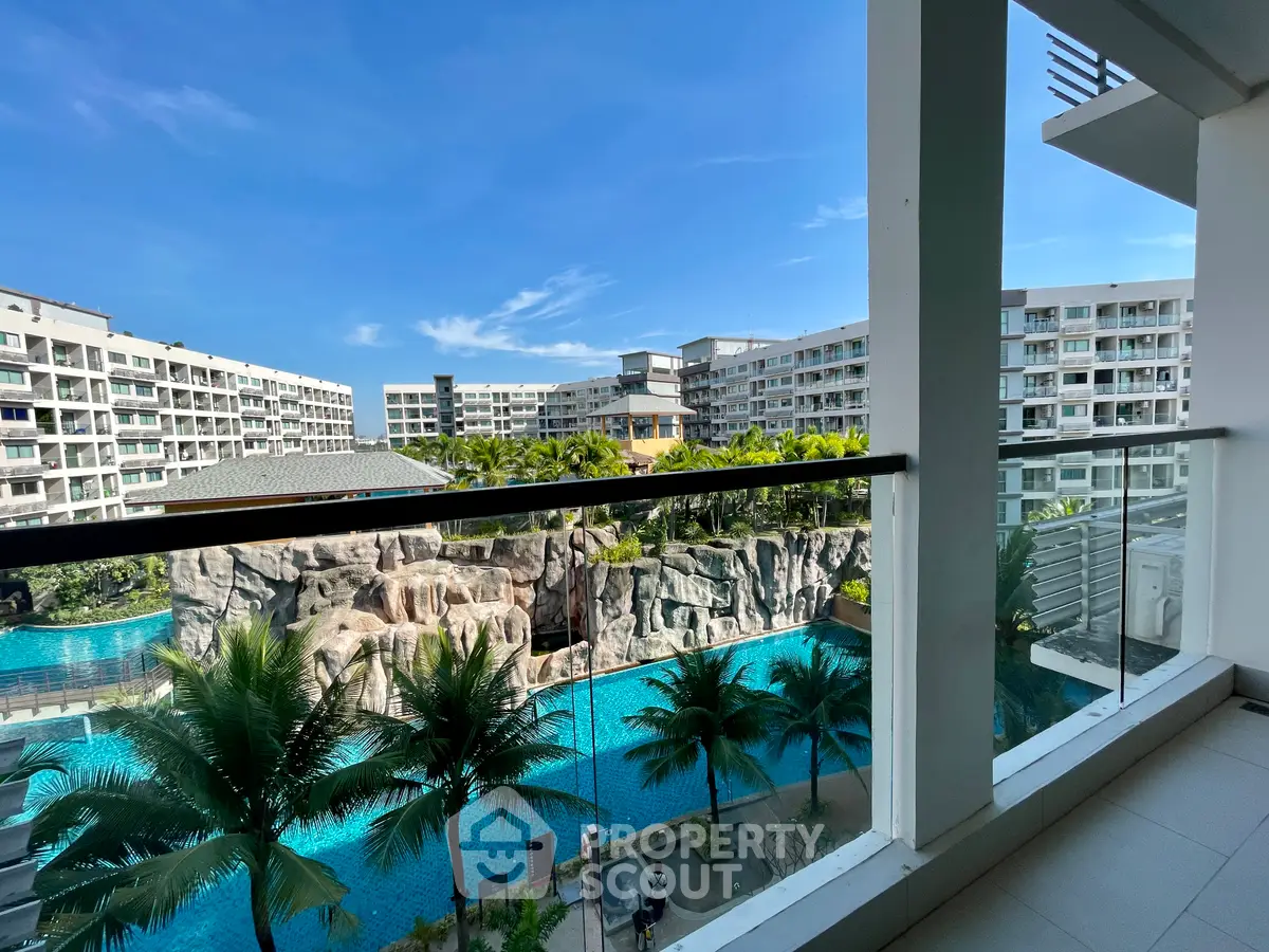 Luxurious balcony view overlooking resort-style pool and modern apartment complex.