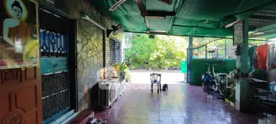 Spacious covered outdoor area with tiled flooring, ceiling fan, and garden view, perfect for relaxation.