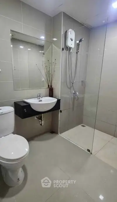Modern bathroom with glass shower and sleek fixtures in a contemporary apartment.