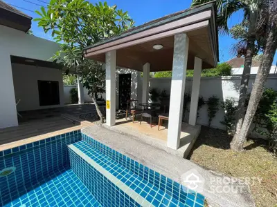 Charming outdoor patio with pool and lush greenery in a serene residential setting.