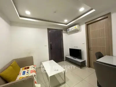 Modern living room with cozy sofa, flat-screen TV, and sleek air conditioning unit.