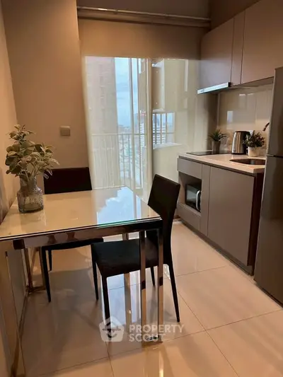 Modern kitchen with sleek cabinetry, dining table, and balcony view in a stylish apartment.