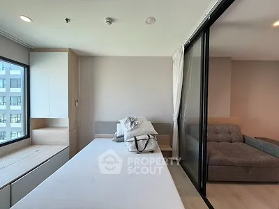 Modern studio apartment with sliding glass partition and cozy furnishings