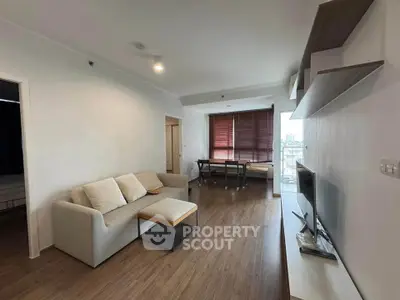 Modern living room with sleek furniture and large windows offering natural light.