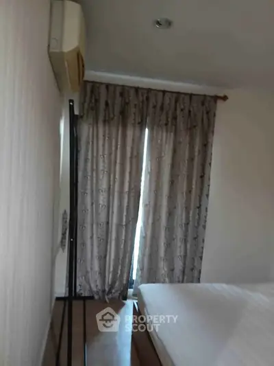 Cozy bedroom with air conditioning and elegant curtains, perfect for restful nights.