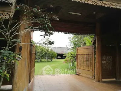 Charming wooden entrance opening to lush garden with traditional architecture