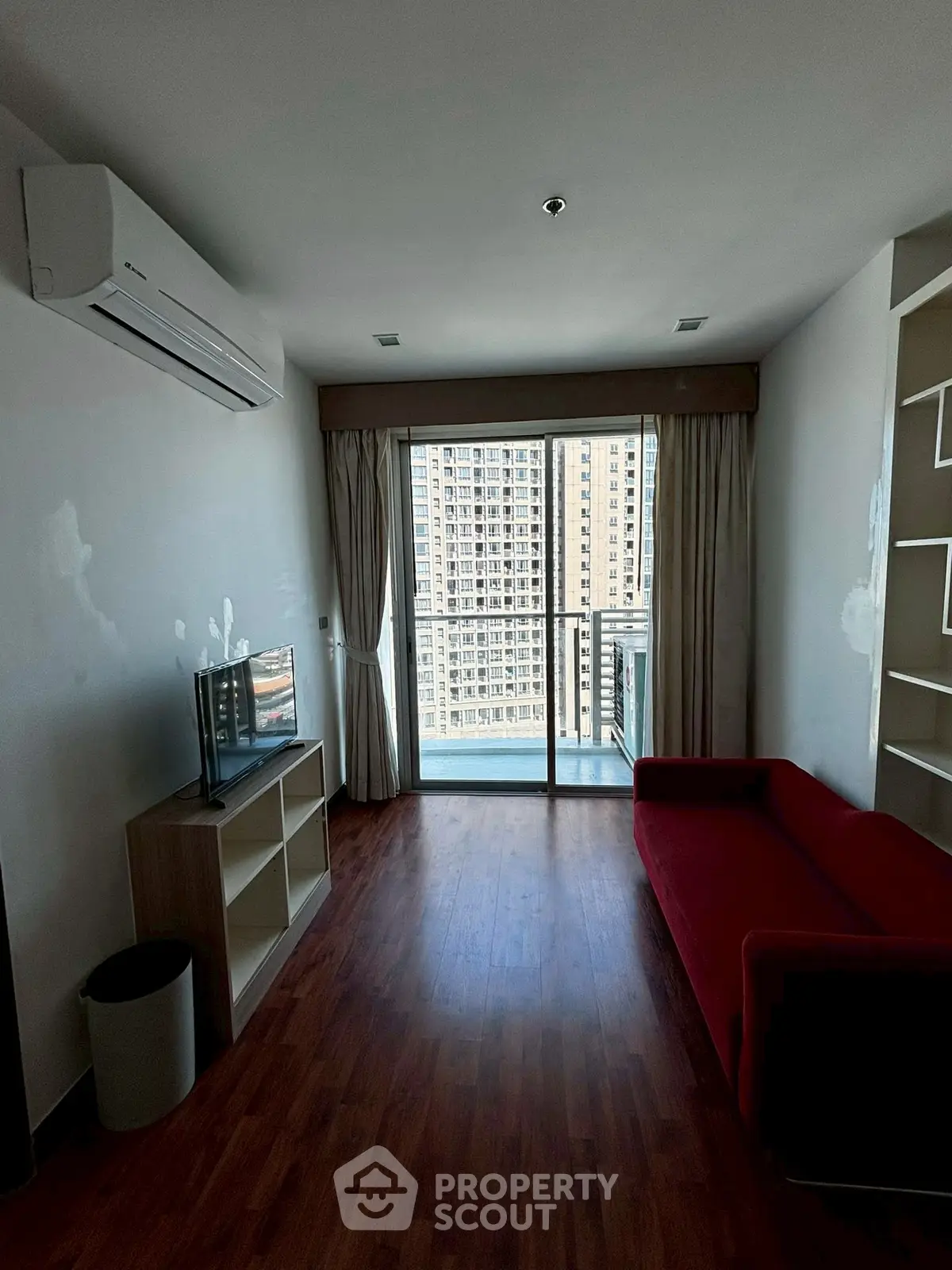 Modern living room with red sofa and city view balcony
