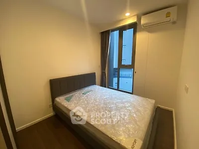 Modern bedroom with large window and air conditioning in a stylish apartment.