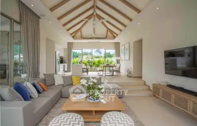 Spacious modern living room with vaulted ceiling and garden view, perfect for relaxation and entertainment.
