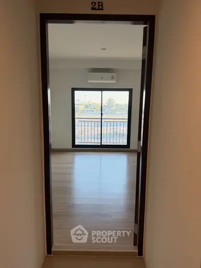 Spacious apartment with large window and balcony view, perfect for natural light lovers.
