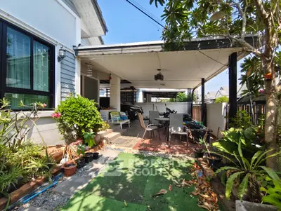 Charming home exterior with lush garden and spacious patio area