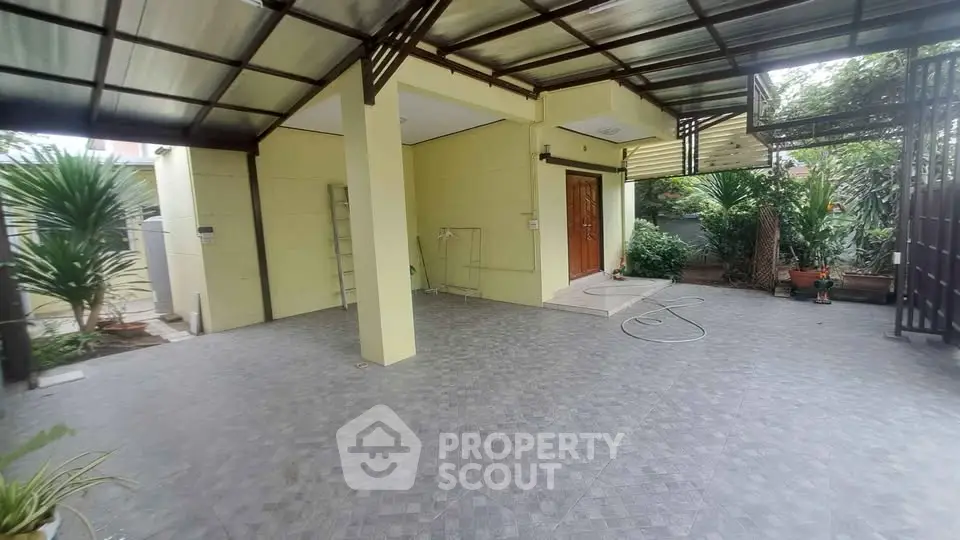 Spacious covered patio with tiled flooring and garden view