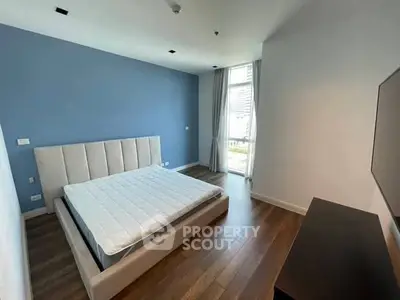Spacious modern bedroom with large window and stylish decor